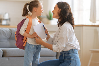 Mother and daughter with backpack and notebook