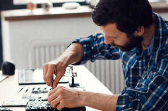 A man repairing a laptop computer.