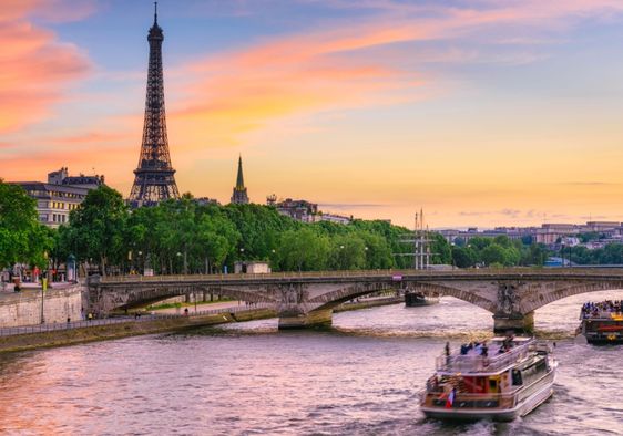 Boats in the the Seine River go past the iconic Eiffel  Tower in Paris.