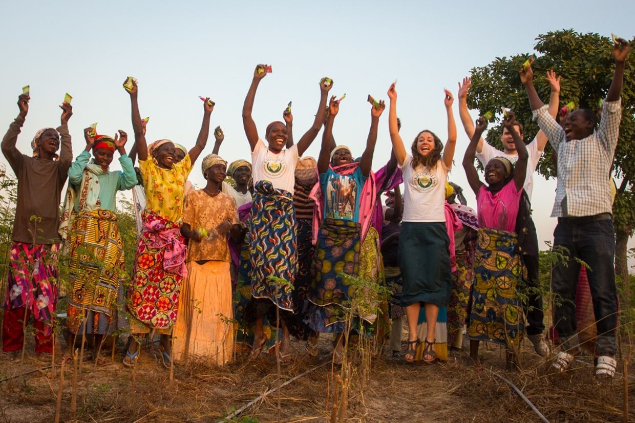 Kuli Kuli founder Lisa Curtis celebrates with female farmers in Nigeria.