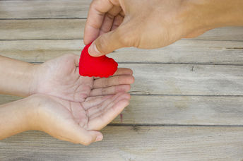 Hand handing over a heart