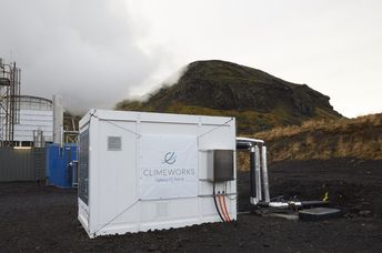 Direct air capture unit along with the cooling towers of the geothermal power plant in Hellisheidi, Iceland.