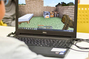 Boy playing Minecraft on PC. Minecraft is a very popular game for all devices.