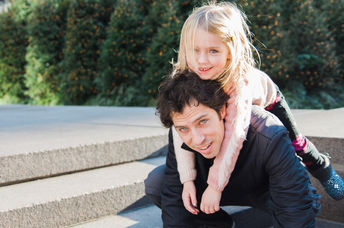 Father and small daughter walk in the park