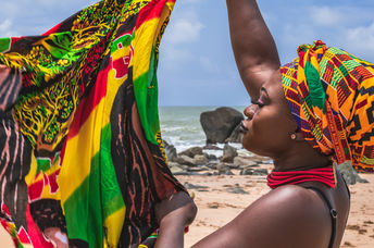 A West African woman holds colorful fabric.