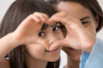 P&G Leads With Love, like this young girl forming a heart with her hands.