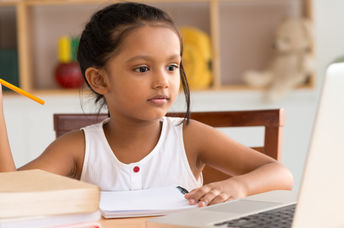 Khan Academy helps students with remote learning like this young girl studying online at home.