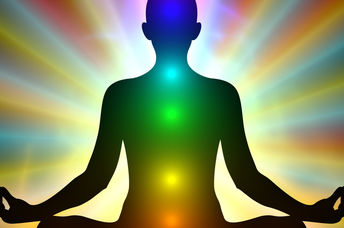 Aura colors and glowing chakras on a man who is meditating.