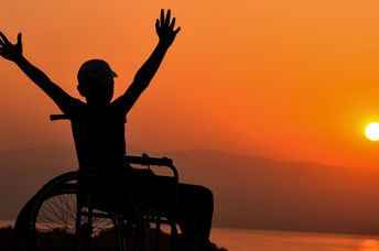 Wheelchair user enjoying a sunset by the sea