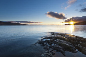 Beautiful sunset over a rocky lake in Scotland promotes spirituality.