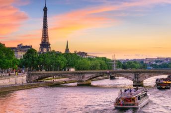 Boats in the the Seine River go past the iconic Eiffel  Tower in Paris.