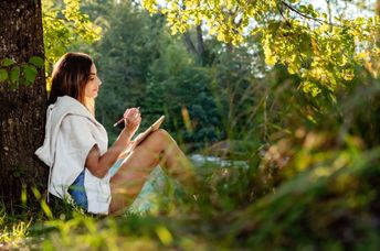 Woman journaling out in nature.