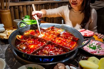 Woman eating original mala spicy hot pot