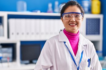 Young scientist in lab coat celebrating new research achievements.