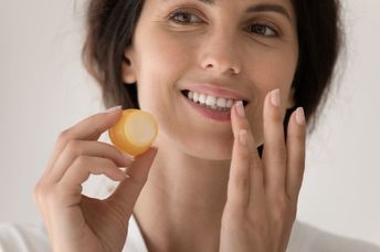 Appling DIY lip balm to chapped lips.