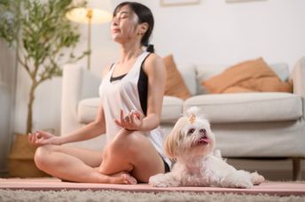 Woman meditating with her dog.