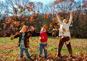 Children playing outside with leaves.