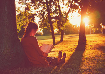 Girl reading by tree