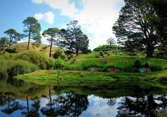 Huts from the Lord of Rings movie set can be seen popping out from the grass.