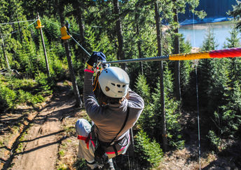 Woman sliding on a zip line in an adventure park (Shutterstock)