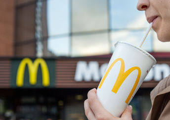 Woman drinks a drink in the background of the McDonald's restaurant