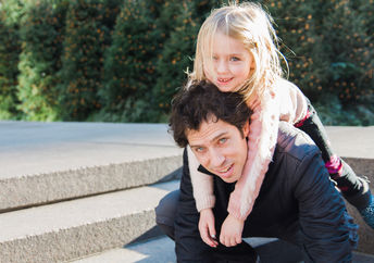 Father and small daughter walk in the park