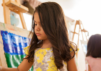 Little girl painting with bright colors