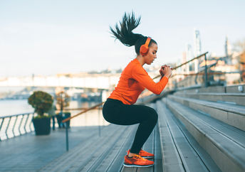 Woman with headphones exercising outside