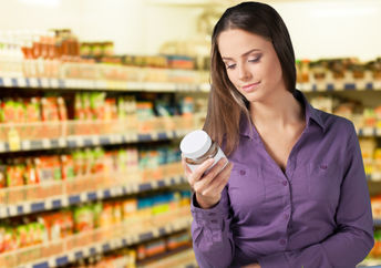 Woman reading food label in supermarket