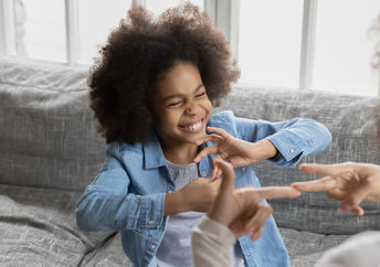 Girl signing with her mother.