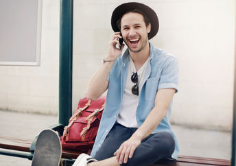 A man laughing at a tram stop.