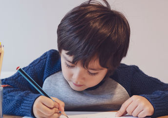 Child writing with a pencil.