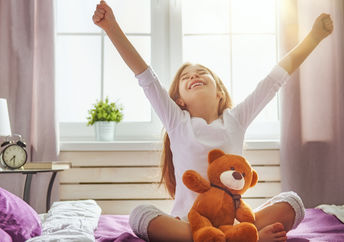 Young girl  happily waking up and stretching.