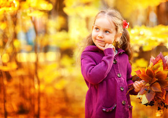 Happy little girl in autumn maple orange leaves