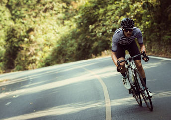 Man riding bicycle on road.