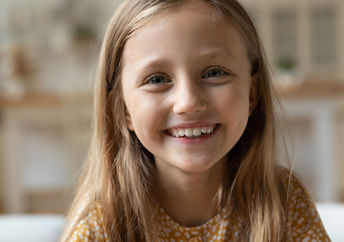 A girl looks at the camera and smiles.