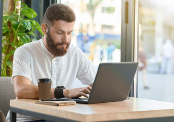 A man works with a laptop.