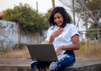 A young woman sitting with her laptop.