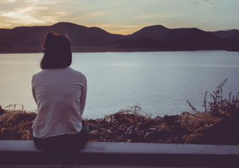 A woman looking at the lake.