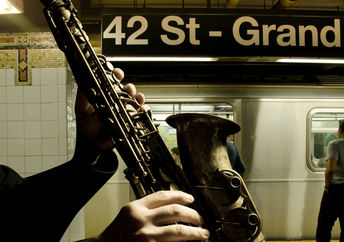 A man playing the saxophone at a subway station.