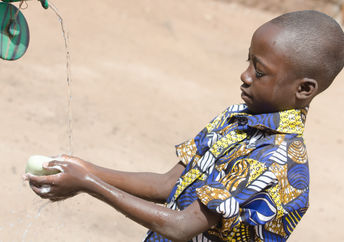 A boy washing his hands.