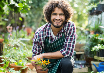 A smiling gardener with a plant.