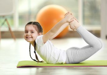 Girl doing yoga on a mat.