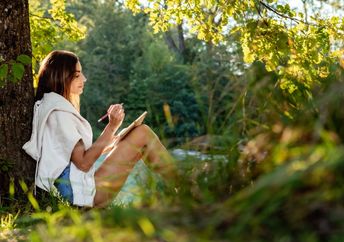 Woman journaling out in nature.