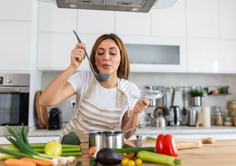 Woman cooking in a host kitchen.