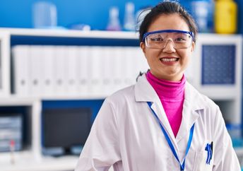 Young scientist in lab coat celebrating new research achievements.