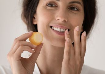 Appling DIY lip balm to chapped lips.