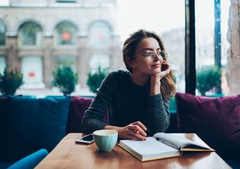 Woman writing her reflections in a journal.