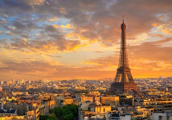 Skyline of Paris with the Eiffel Tower at sunset.
