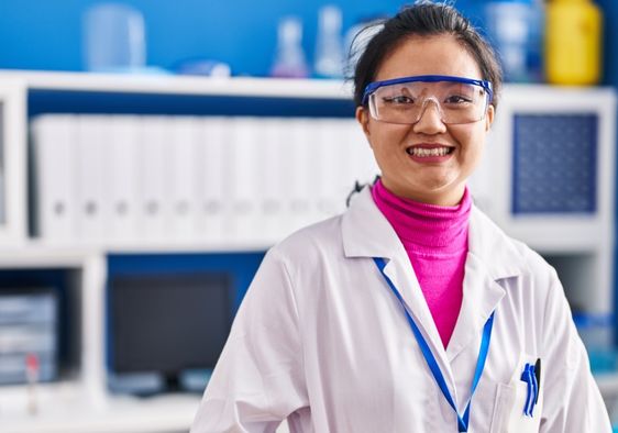 Young scientist in lab coat celebrating new research achievements.